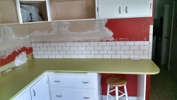 Here we have the beginning of the subway tile installation. The wall where the cabinets once were has been smoothed.