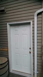 Here is the new door, with the siding replaced. Note: Care was taken in caulking all threshold seams.