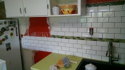 Continuation of the subway tile, going behind the refrigerator.